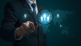 Global recruitment with magnifying glass over team on world map on transparent background