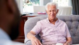 Happy senior man taking financial advice at home