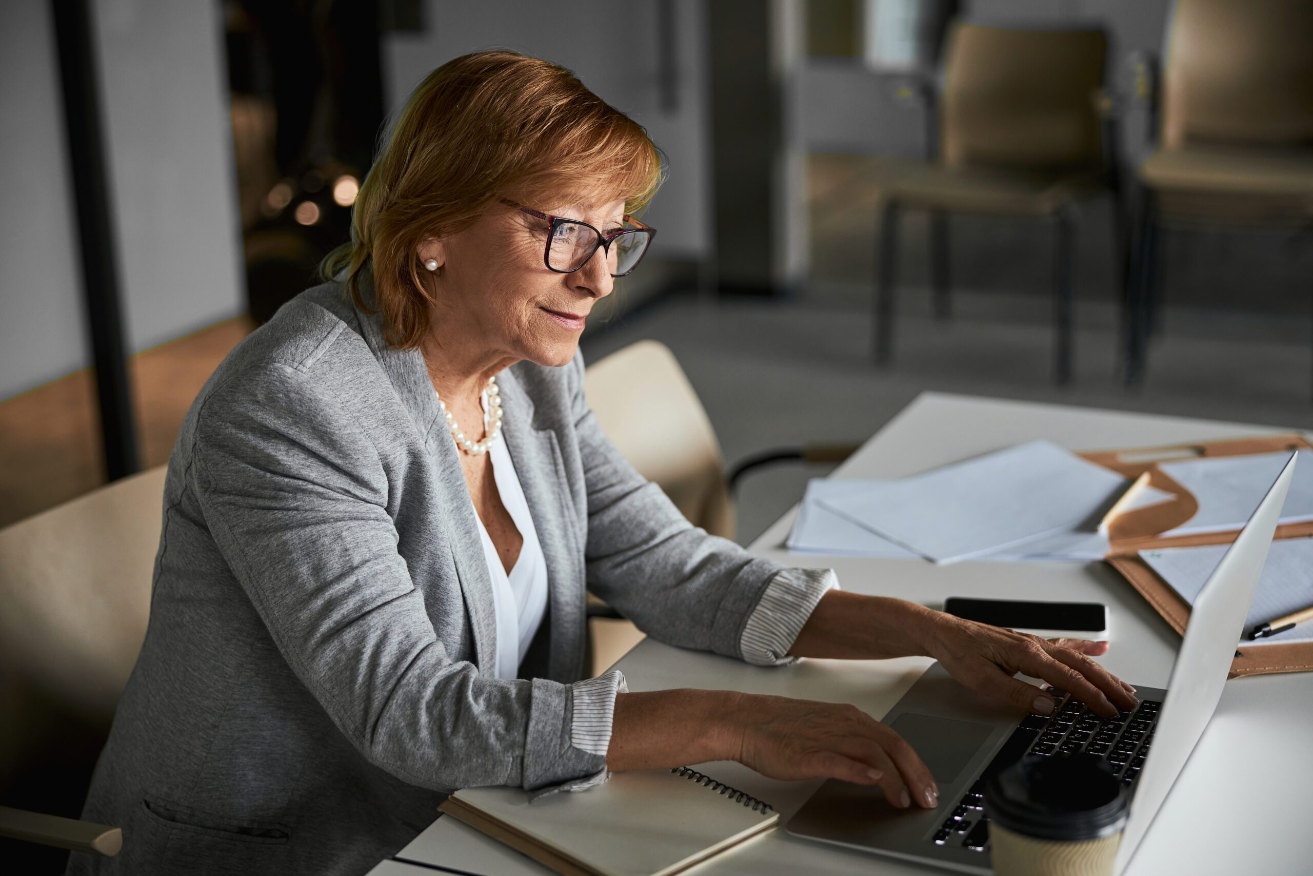 Pleased female company director typing on laptop keyboard
