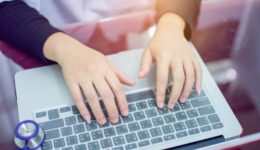 Doctor woman hand typing the Thai keyboard of notebook at the desk for working with blurred of. stethoscope at the hospital office, medical technology concept