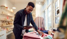 Male Small Business Owner Checks Stock In Shop Using Digital Tablet