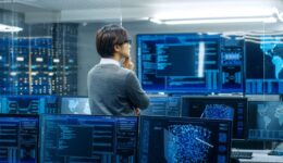 In the System Control Room Technical Operator Stands and Monitor