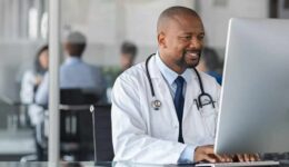 African mature doctor working on computer