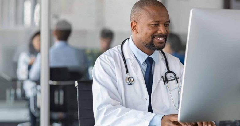 African mature doctor working on computer