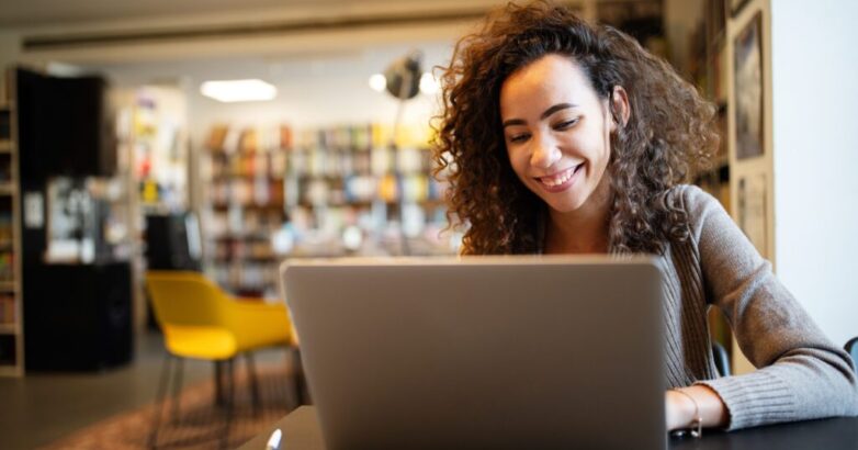 Young beautiful student girl working, learning in college library