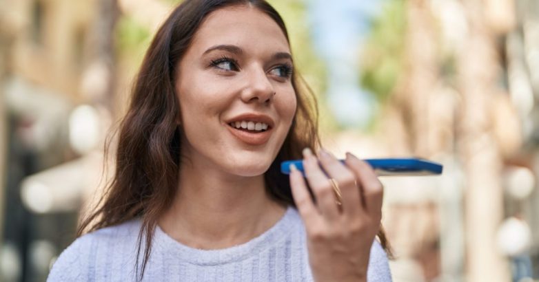 Young woman smiling confident talking on the smartphone at street