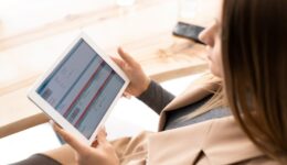 Young elegant businesswoman looking through online financial information