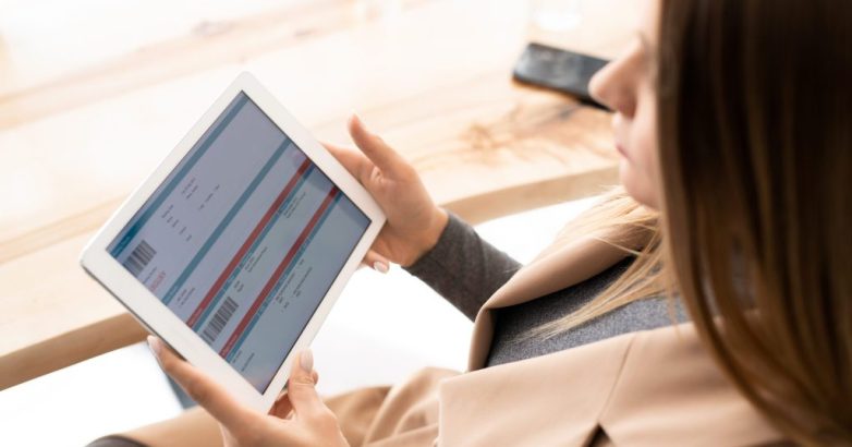 Young elegant businesswoman looking through online financial information