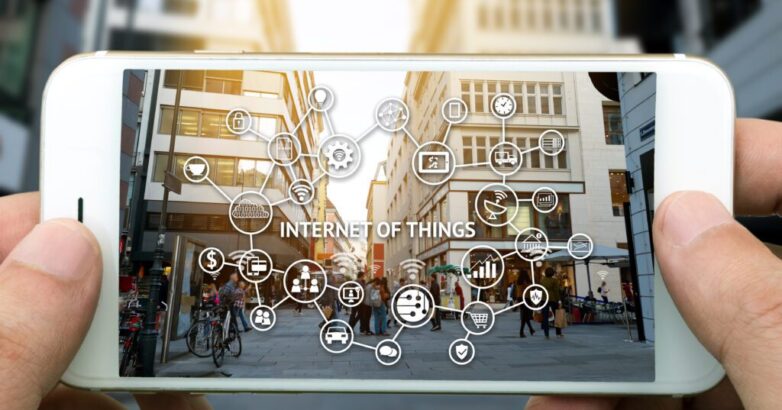 Internet of things (IoT) and digital lifestyle concept . Hand holding smart phone , wifi icons and city view background. Internet of things (IoT) and digital lifestyle concept . Hand holding smart phone , wifi icons and city view background.