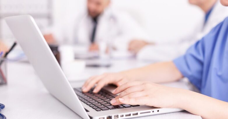 Medical practitioner typing diagnosis