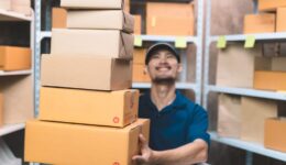 business man in shipping uniform handing customer package prepare for delivery service. man doing work at his small shipping new business and new transportation delivery.