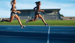 Athletes arrives at finish line on racetrack