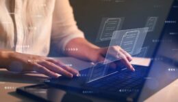 Businesswoman working on laptop with virtual screen. Process automation to efficiently manage files. Online documentation database and document management system concept.