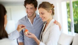 Happy young couple getting keys of their new home