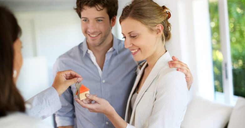 Happy young couple getting keys of their new home