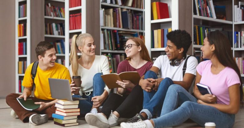 Group of teenage friends having conversation while preparing for exams