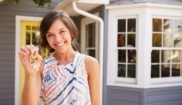 Woman With Keys Standing Outside New Home