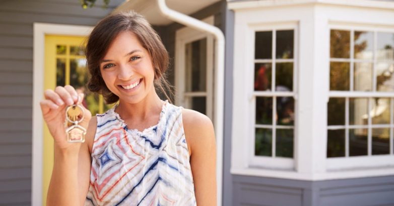 Woman With Keys Standing Outside New Home
