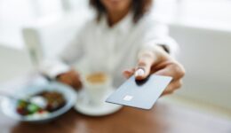Portrait of african american woman paying in cafe with credit card