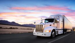 Truck and highway at sunset - transportation background