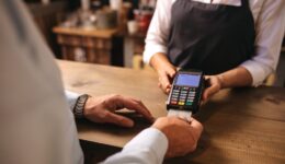 Customer doing payment of coffee by credit card at cafe