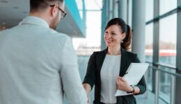 Business people handshake near the office building windows.