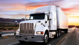 Trucking Truck Driver. White Cargo Truck on the Highway at Sunrise