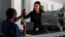 Happy system engineers celebrating successful code script compiling