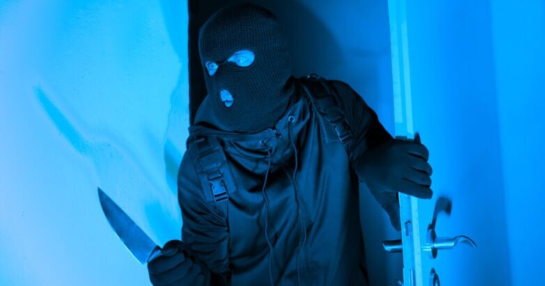 Burglar with knife entering through apartment door