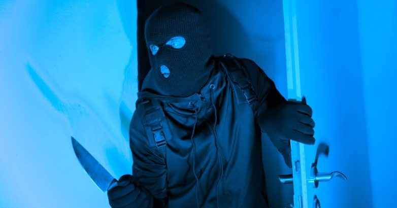 Burglar with knife entering through apartment door