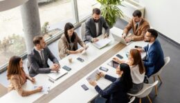 Top view of group of businesspeople sitting at boardroom and discussing data analytic.
