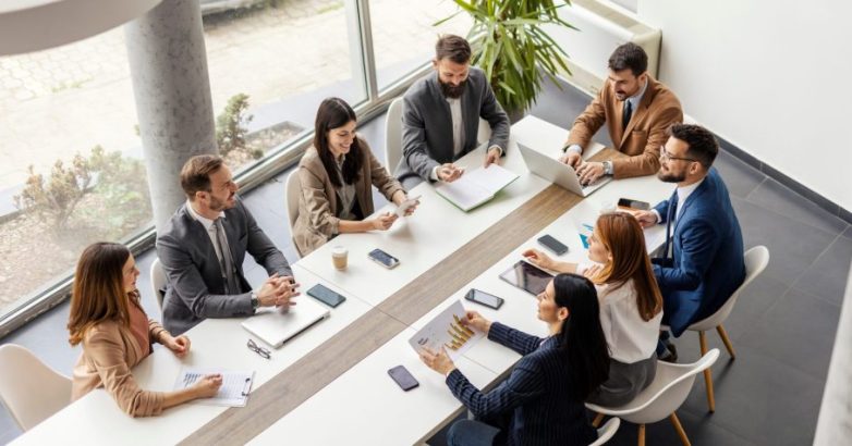 Top view of group of businesspeople sitting at boardroom and discussing data analytic.