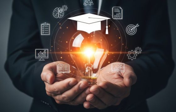 Illuminating Education: Man Holding Lightbulb with Graduation Cap Icon for Learning Concepts and Digital Transformation